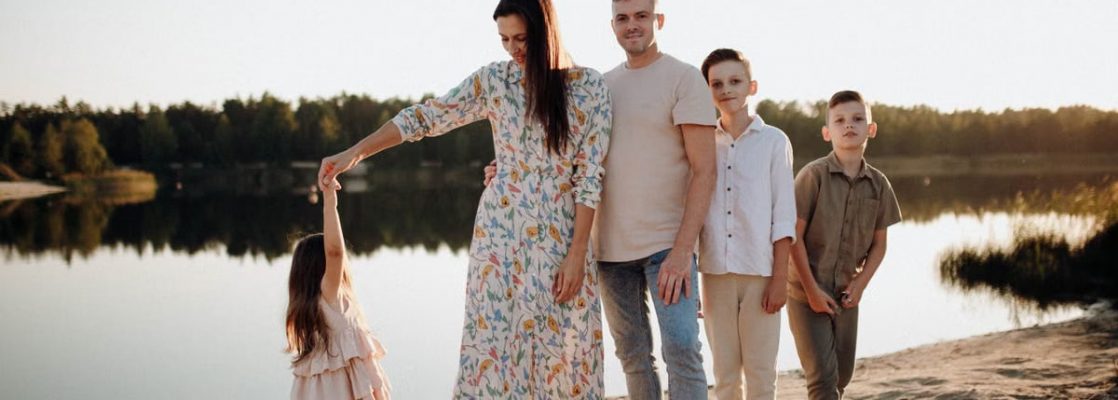 A family of five enjoys a serene lakeside vacation at sunset, capturing precious moments together.